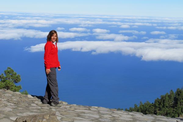 Se ve una fotografía donde se muestra a una mujer por encima de las nubes. 