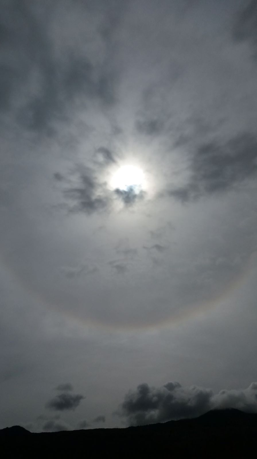 Se ve una fotografía donde se contempla un halo solar. Y en el centro de su aura se ve el azul del  ojo de dios., 