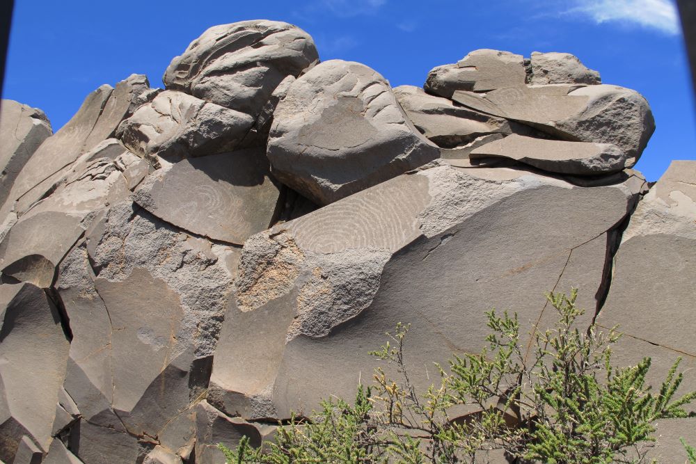 Se ve unas piedras con pinturas rupestres, con formas circulares de tiempos ancestrales