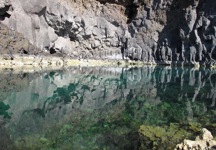 reflejos en el agua de sal entre rocas volcánicas