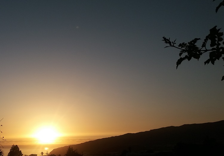 Se ve un atardecer con el sol en círculos concéntricos. Por encima de él, se ve la luna, pero no puede ser. El sol y la luna no caminan juntos; bailan al unísono