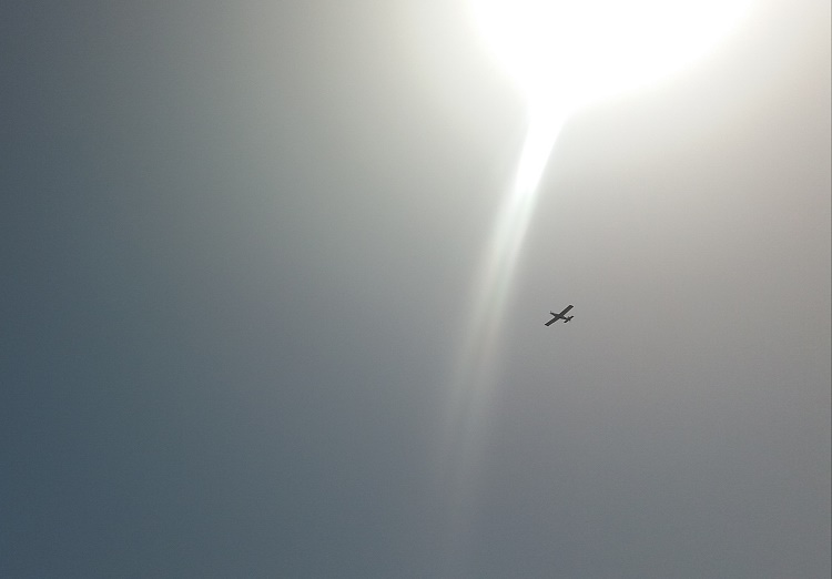 Se ve los torbellinos del sol caliente de calima, y un avioneta sobrevuela para vigilar un fuego, que como el Sol, todo lo quema.