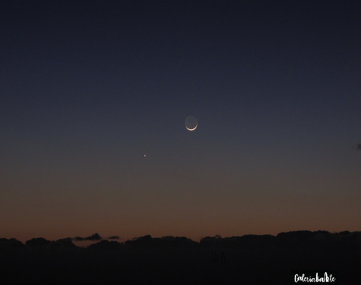 Se ve la luna menguante, y un planeta que brilla a su lado. Desde tierra un telescopio y una gran cordillera, un tenue mar de nubes