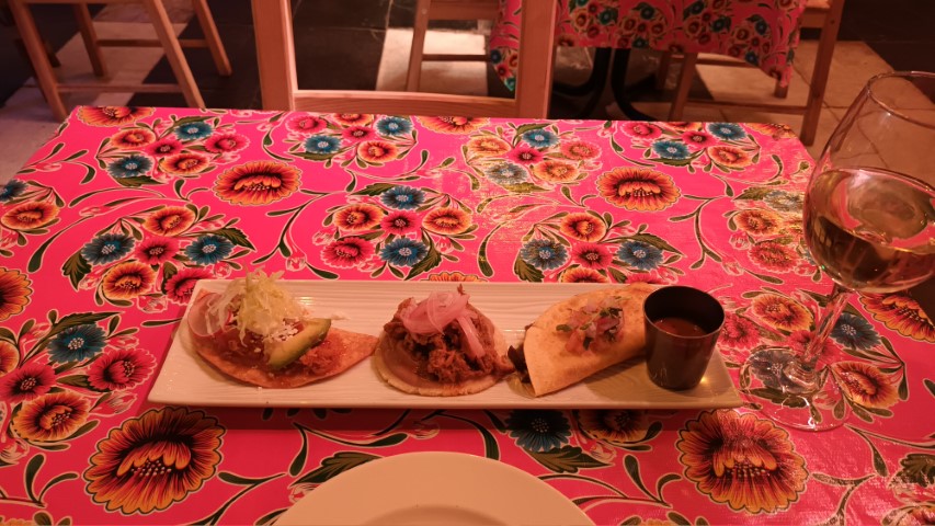 una comida mexicana llena de picante y tortitas de maíz acompañada de un vino blanco seco