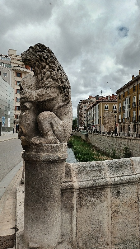 Se ve la puerta de entrada a Burgos, custodiada por unos de sus leones
