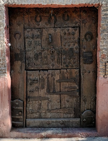 Puertas labradas con preciosos picaportes. Medievo de libros.