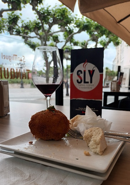 Se ve una copa de vino de Ribera del Duero y un tapeo típico español