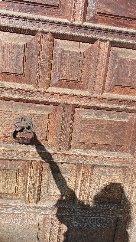 Se ve una puerta y un brazo paea tocarla, abrirla y entrar